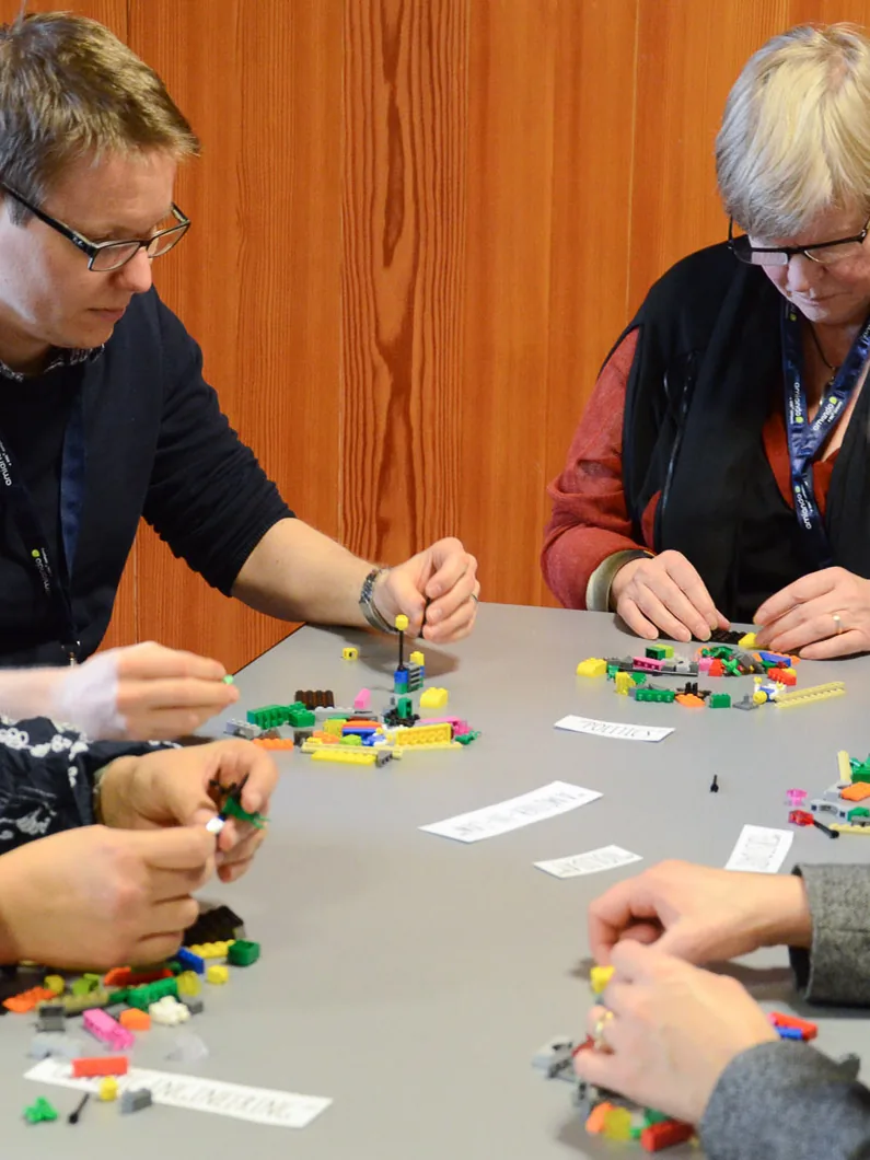 Participants concentrés sur leurs modèles en briques
