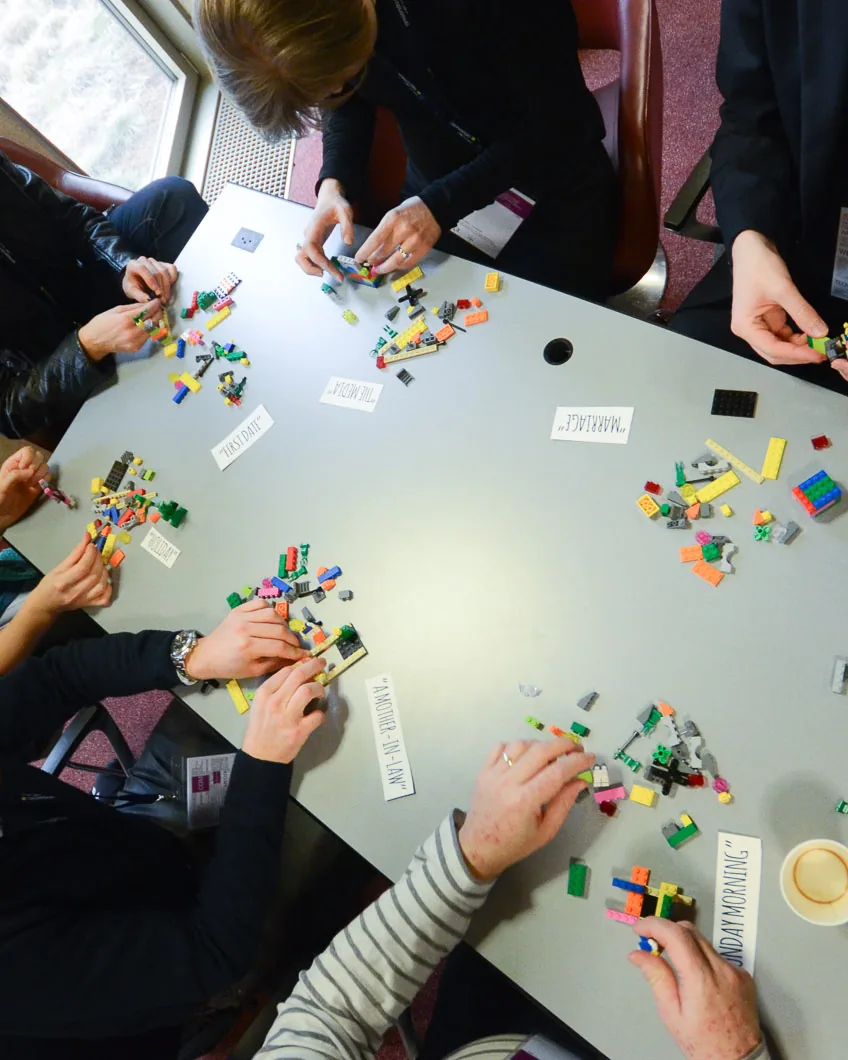 Vue en plongée d'un groupe en atelier construisant avec des briques colorées