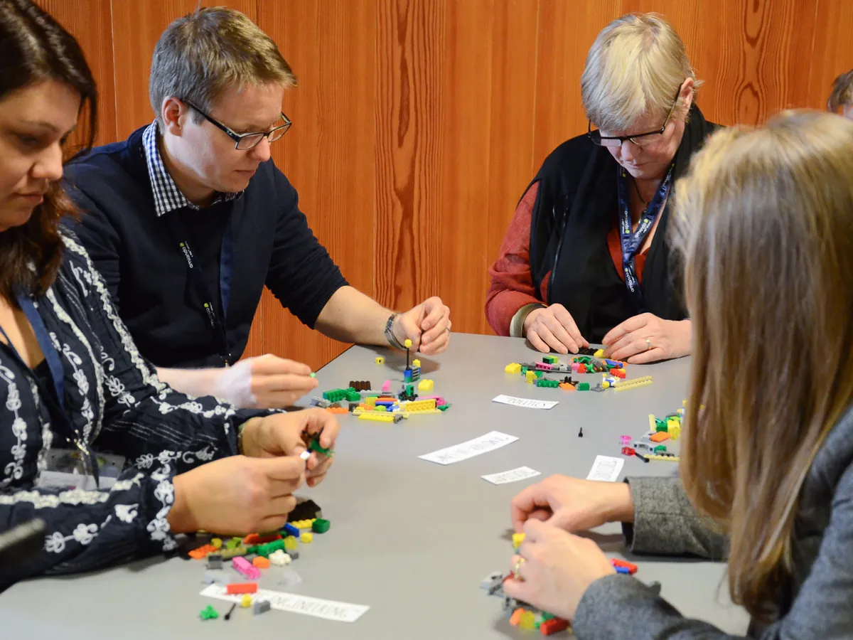 Participants concentrés construisant des modèles en briques